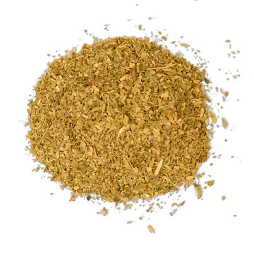 A light blue tea box with white writing sitting behind some loose leaf tea leaves.