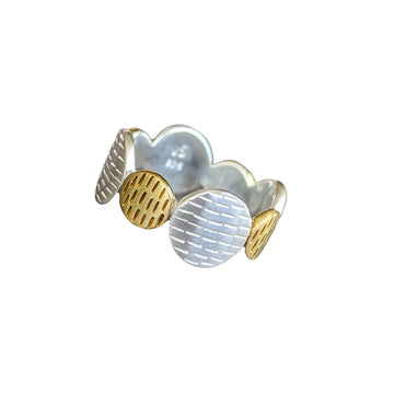 A gold and silver ring with alternating circles in different colours and sizes.