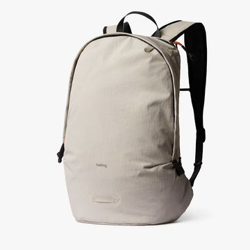 Beige backpack with black straps on a white background.