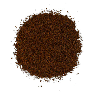 A grey box of tea with white writing sitting behind black loose leaf tea.