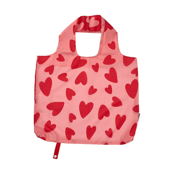 A reusable shopping bag in pink with red hearts printed on it.