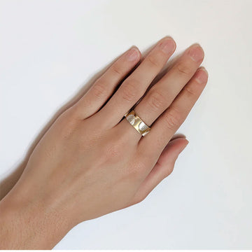 A gold ring with silver semi circles alternating sizes on the ring.