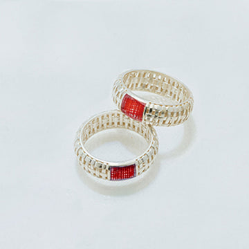 Two rings with red gemstones on a light gray background.