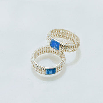 Two rings with blue gemstones on a light gray background.