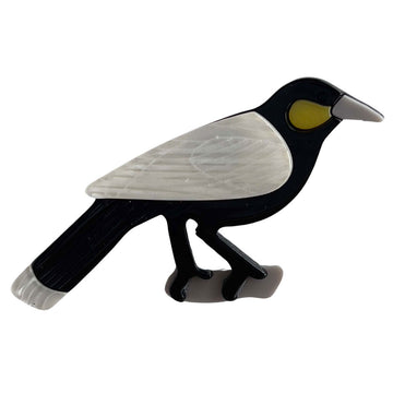 A resin brooch shaped like a magpie.