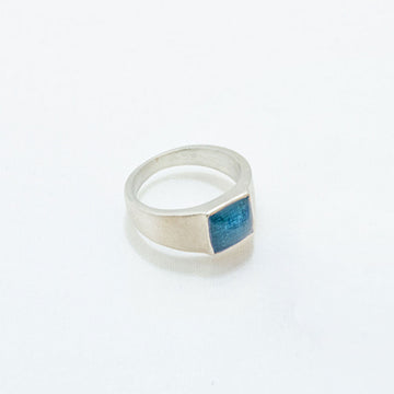 Silver ring with a blue stone on a white background.