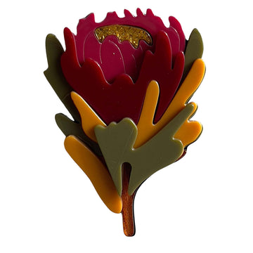 A resin brooch shaped like a waratah flower.