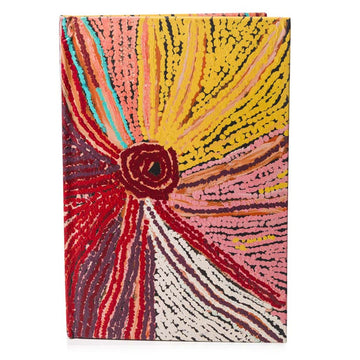 A hardcover journal printed with artwork by May Wokka Chapman on the front in shades of red and yellow.