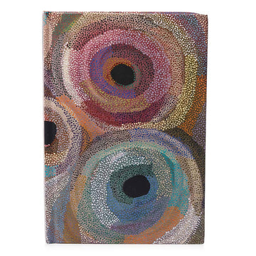 A hardcover journal with artwork by Marianne Burton on the cover with red and blue circles.