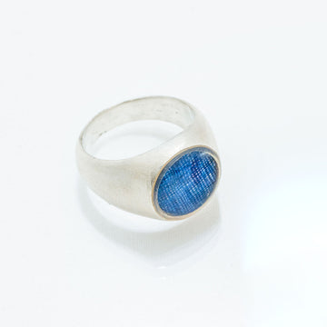 Silver ring with a blue gemstone on a white background.