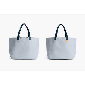 Light blue tote bag with blue handles on a white background.