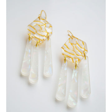 A pair of drop earrings with a gold hexagon shape with three long tear drops hanging below.