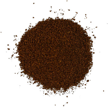 A grey box of tea with dark green text sitting behind some fruit and loose leaf tea.