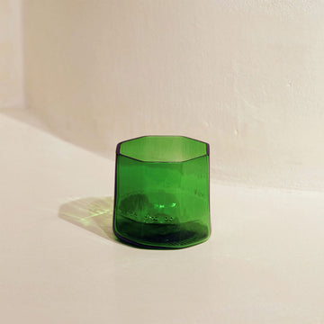 A glass hexagon shaped tumbler in green.