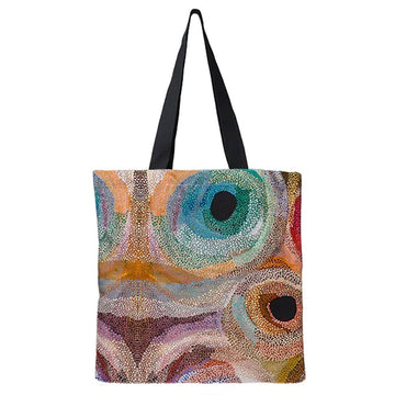 A tote bag printed with artwork by Marianne Burton with coloured circles.