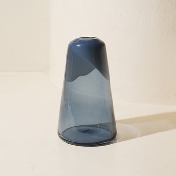 Blue glass vase on a light beige background.
