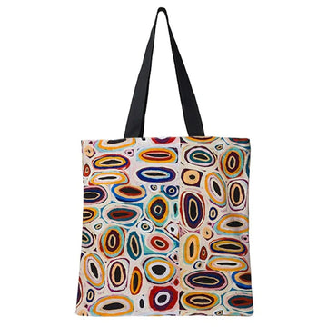 A tote bag printed with artwork by Gladys Kuru Bidu in different coloured ovals.