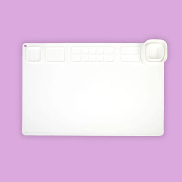 A white activity tray with a few grooves for holding small craft items and paints.