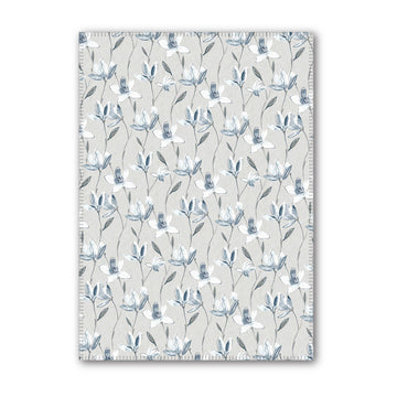 A tea towel printed with magnolia flowers.