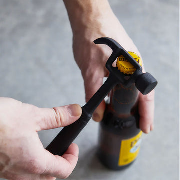 A hammer shaped bottle opener attached to a brown card with the heading 'Hammer Bottle Opener'.