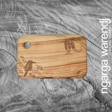 Wooden cutting board with engraved designs on a textured gray background, featuring the brand 'ngarga warendj'.