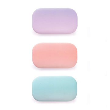 Three small hard shell cases in purple, peach and mint green.