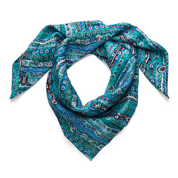 A linen scarf printed with artwork by Murdie Morris in blue is looped over.