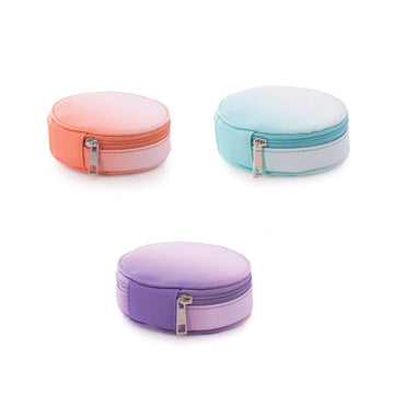 Three round cases with zipper closures in peach, mint green and purple.