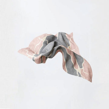 A silk scarf printed with a grey and pink pattern in a flowing shape.