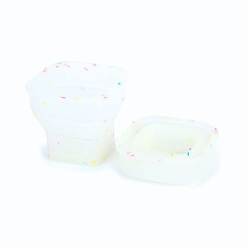 A collapsible cup shown in white speckled in both its full form and collapsed form.