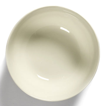 Side view of a white ceramic bowl with blue stripes.