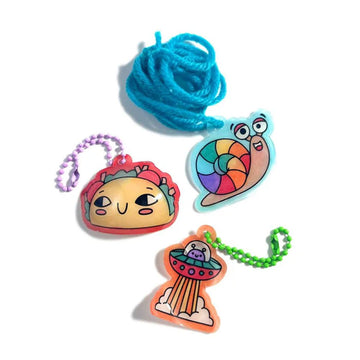 Shrink-Its DIY Shrink Art Kit packaging with colorful shrink charms on a green background.