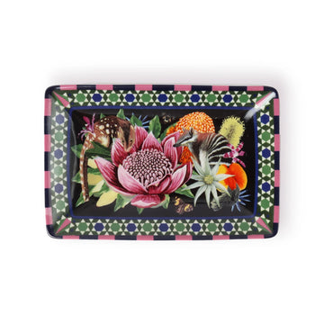 A ceramic trinket tray in a rectangle shape printed with an illustration of a pink flower with animals and other flowers around it.
