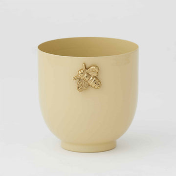 A pot planter box in a honey colour with a gold bee on the front top.