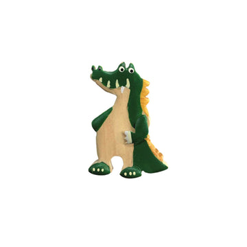 A timber magnet shaped and painted like a crocodile standing.