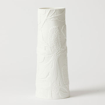 A tall cylinder shaped vase in white porcelain embossed with banksia flowers.