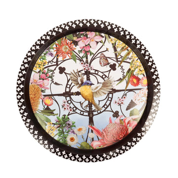 Decorative round tin plate with floral and bird design on a white background