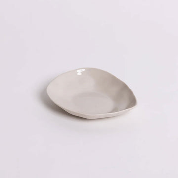 A ceramic condiment bowl in an irregular oval shape.