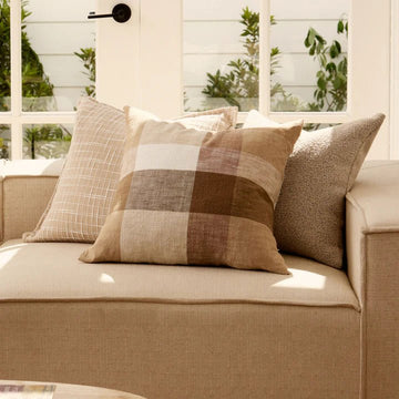 An image of a cushion with a white slub check design on an oatmeal background.