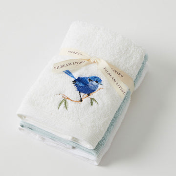 Three face washers folded up and tied together. The top face washer is embroidered with a blue wren.