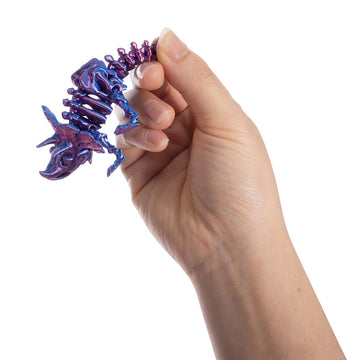Five 3D printed dinosaur toys pictured in different colours.