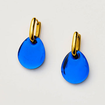 Blue earrings with gold hooks on a light gray background.