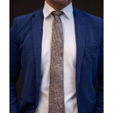 A men's tie rolled up with the end open printed with a brown stripe design.
