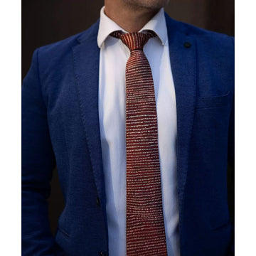 A red tie with cream coloured dots in horizontal lines.