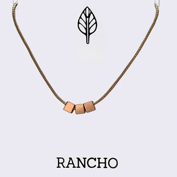 Necklace with geometric cube pendants on a light gray background, featuring the brand 'RANCHO'.