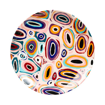 Colorful abstract patterned ceramic plate on a white background.