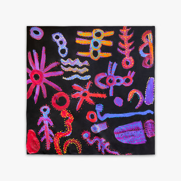 A black silk scarf printed with red and purple Indigenous artwork.