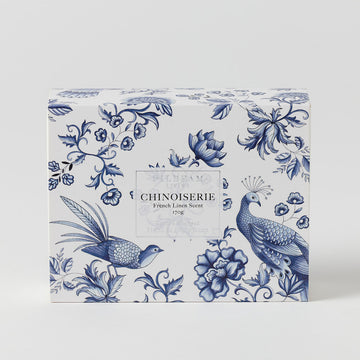 A blue and white box illustrated with birds and flowers and the text 'Chinoiserie French Linen Scent' in a box in the middle.