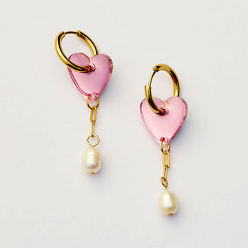 Heart-shaped earrings with pink hearts and pearl drops on a light gray background.