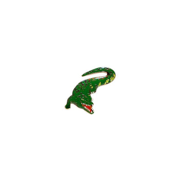 An enamel badge in the shape of a crocodile.